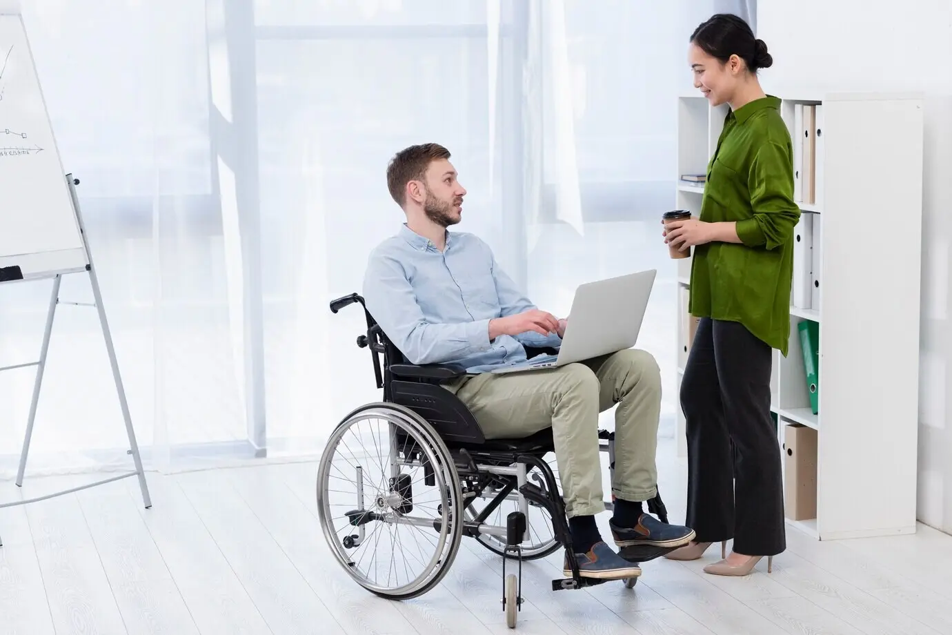 Мужчина в инвалидной коляске, снятый в полный рост.