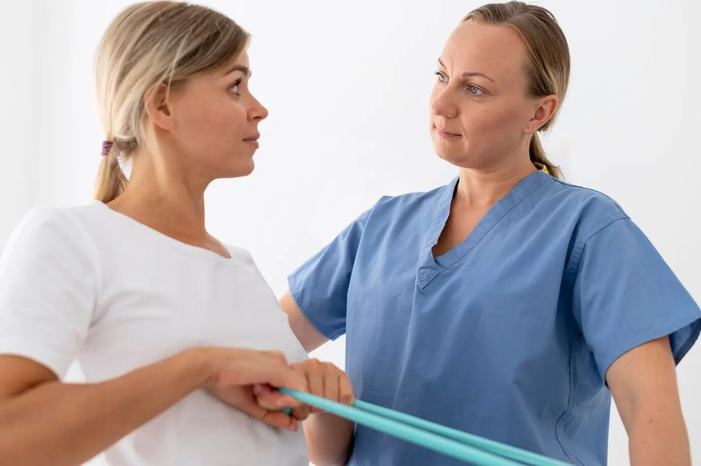 Женщина выполняет упражнение на сеансе физиотерапии.